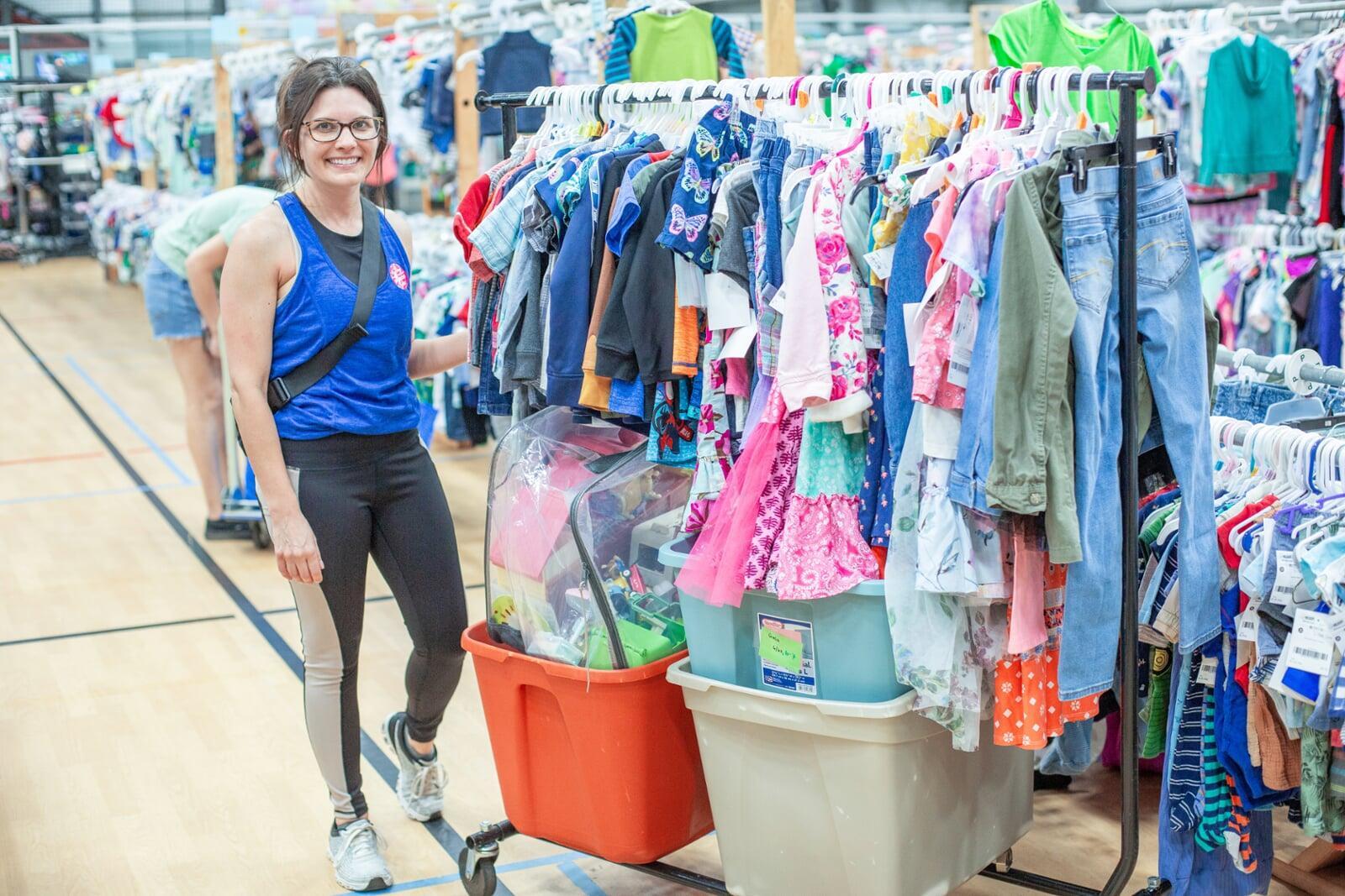 Mom and grandmother stand together, a few pieces of clothing in grandmom's hands, as they shop together for their family.